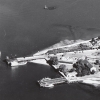 <p>Aerial view of the Freight Pier (upper) and Passenger Dock (lower) on the shore of Fort Slocum&#39;s Quartermaster Area, looking north, late 1950s.</p>